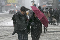 <p>Pedestrians use an umbrella as a shield against high winds and snow as they cross the street in Times Square, Feb. 9, 2017, in New York. (Gordon Donovan/Yahoo News) </p>