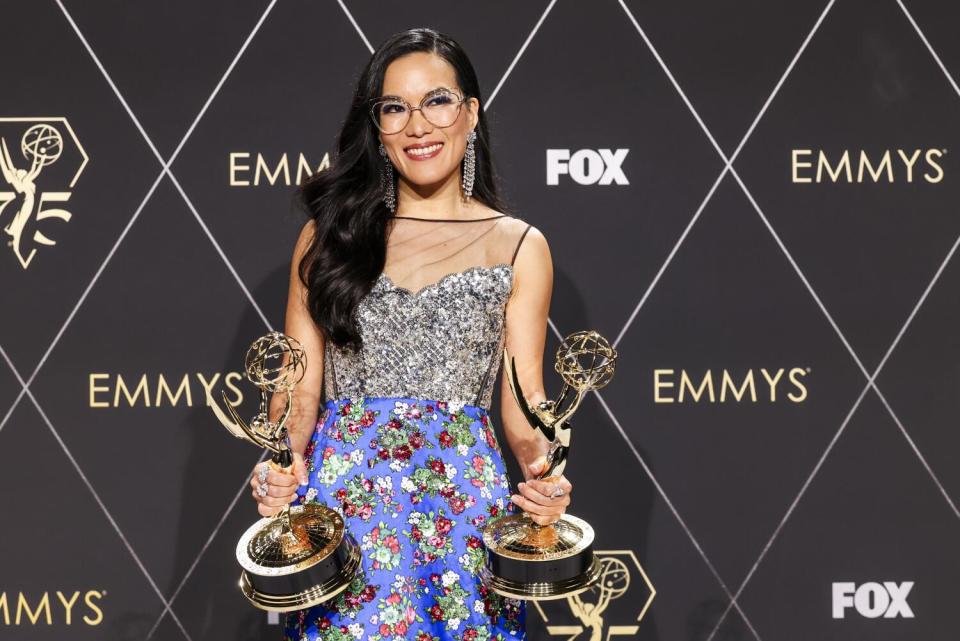 An actor holds two Emmy awards.