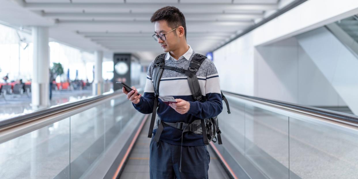 traveler at airport on phone with luggage