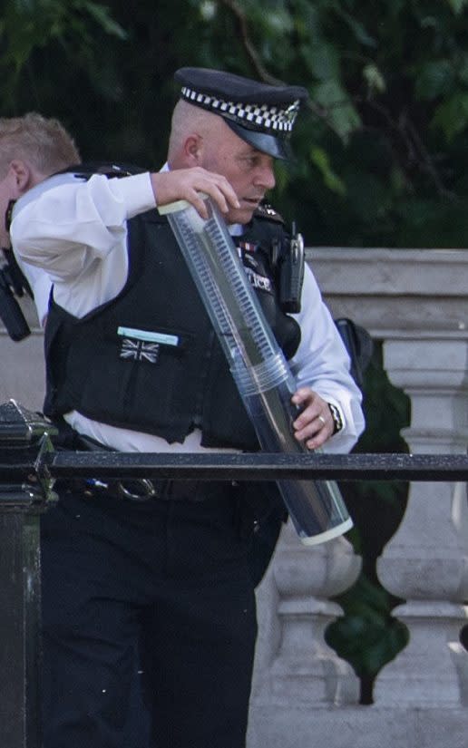 A police officer holds what is believed to be a large knife that is thought to have been seized from the man outside Buckingham Palace - Credit: Carl Court/Getty 