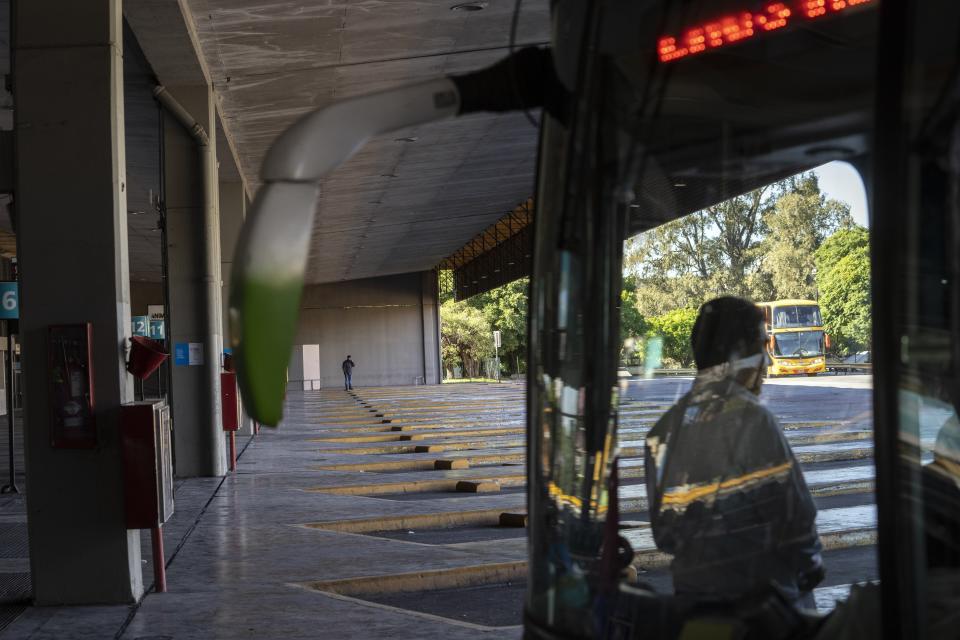 A driver stands inside a bus at the Retiro long-distance bus terminal that is empty due to a general strike against the reforms of President Javier Milei in Buenos Aires, Argentina, Thursday, May 9, 2024. (AP Photo/Rodrigo Abd)