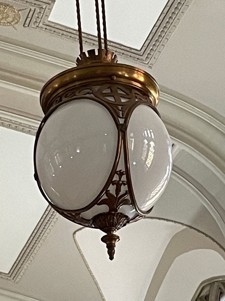 One of the community room's Neo-Jacobean chandeliers is shown.
