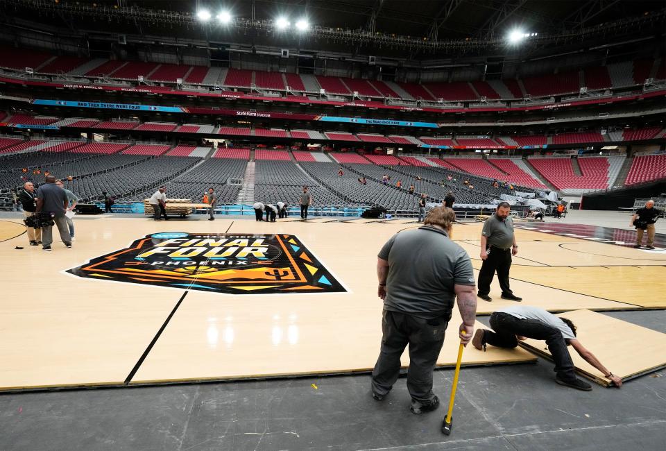 Workers install the 2024 NCAA Men's Final Four Official Court at State Farm Stadium in Glendale on March 29, 2024. This Final Four is just the second time Arizona is hosting the event.