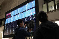 Members of media film the blank stock board at Tokyo Stock Exchange Thursday, Oct. 1, 2020, in Tokyo. The Tokyo Stock Exchange temporarily suspended all trading due to system problem. (AP Photo/Eugene Hoshiko)