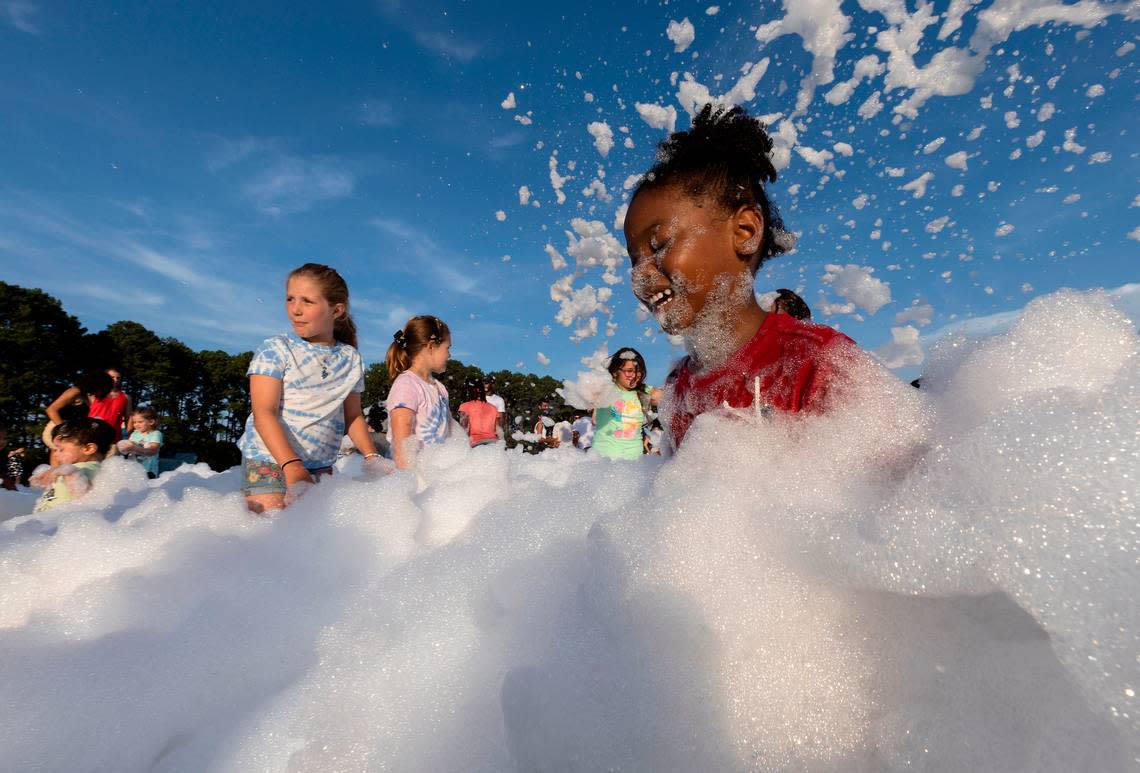 Alani McGuire, 5, laughs while playing in a foam pit during an Independence Day celebration at Dorothea Dix Park on Tuesday, July 4, 2023, in Raleigh, N.C. Kaitlin McKeown/kmckeown@newsobserver.com