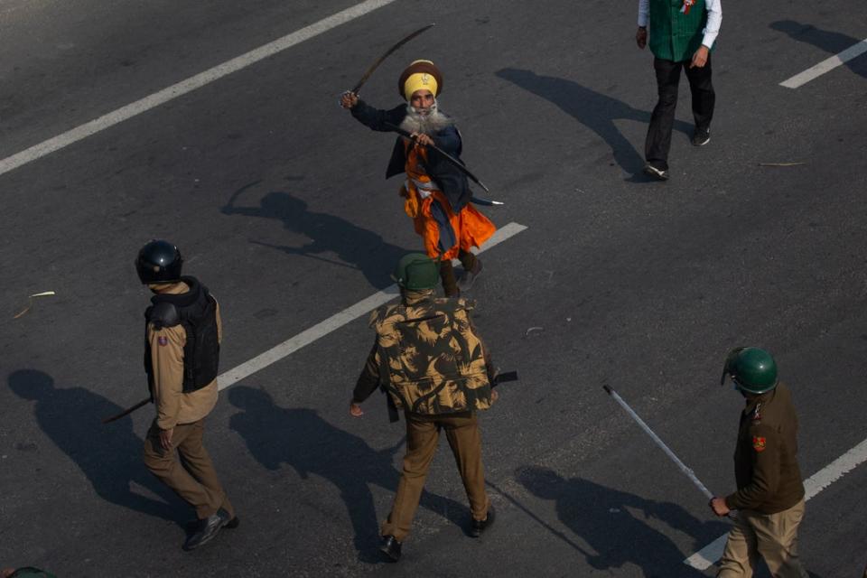 In this January 2021 photo, a Nihang brandishes a sword at policemen as protesting farmers march to the capital breaking police barricades during India's Republic Day celebrations in New Delhi (AP)