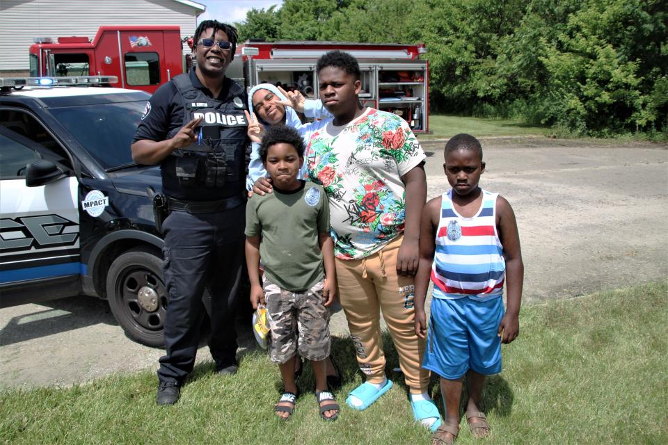 Officer Montel Smith of the Marion Police Department takes time to get a photograph with some of the kids who came to the first installment of Hot Dogs & Heroes on Wednesday, June 8, 2022, at Fairview Apartments in Marion. Smith is the juvenile officer for the department's MPACT (Marion Police and Community Together) program.
