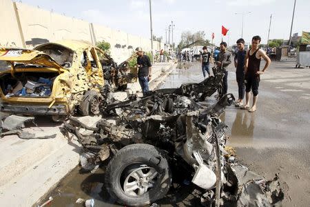 Iraqi men inspect the site of car bomb attack in the Saydiya district of southern Baghdad, Iraq May 2, 2016. REUTERS/Khalid al Mousily