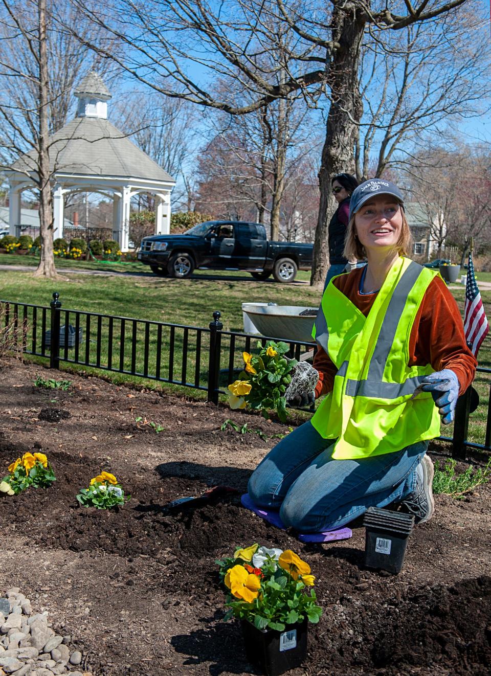 Reka Au, a member of the Hopkinton Garden Club, plants some of the 340 plants that Garden Club volunteers arranged on the Hopkinton Town Common a week before the Boston Marathon, April 10, 2023.