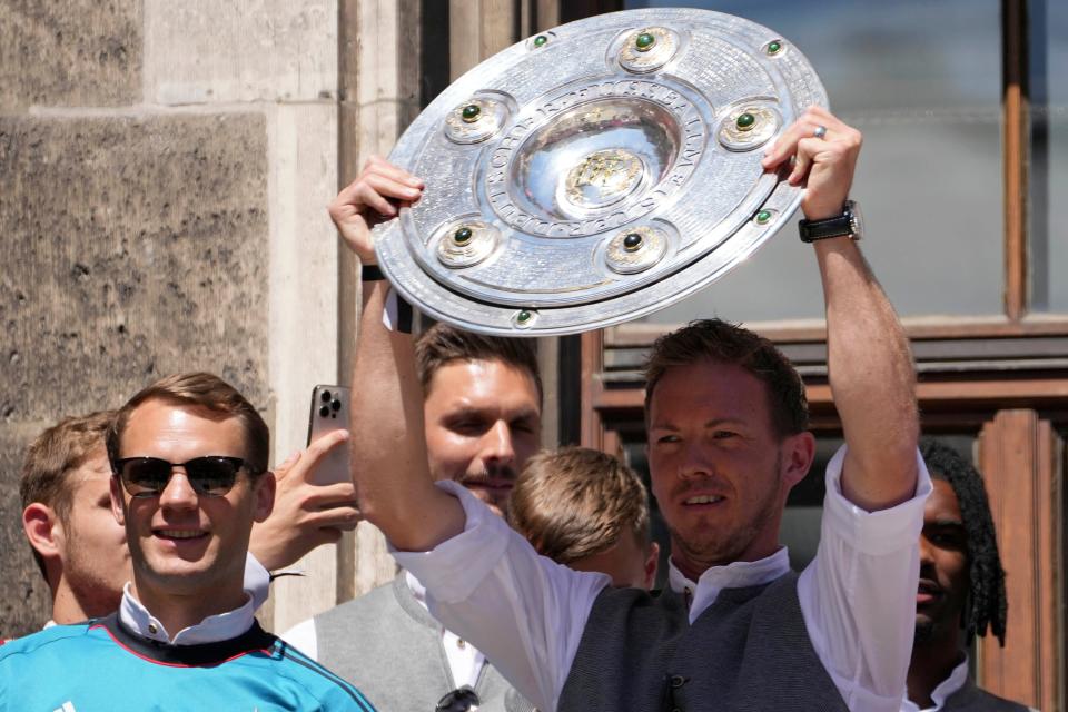 Bayern coach Julian Nagelsmann lifts the trophy as he stands on the balcony of the town hall at Marienplatz square celebrating the 31st Bundesliga title May 15, 2022, at the German Bundesliga in Munich, Germany.