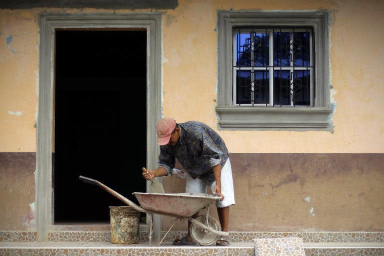 A man works in the construction of a house in Intipuca where money sent by emigrants to the US has helped build a stadium, church, schools and cultural center