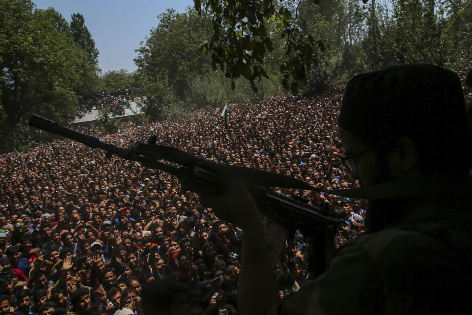 FILE - In this Aug. 4, 2018, file photo, a Kashmiri rebel fires his gun to salute fallen comrades during their joint funeral in Malikgund village, south of Srinagar, Indian controlled Kashmir. New Delhi initially grappled with largely peaceful anti-India movements in its controlled portion of Kashmir. However, a series of political blunders, broken promises and a crackdown against dissent escalated the conflict into a full-blown armed rebellion against Indian control in 1989 for a united Kashmir, either under Pakistan rule or independent of both. Since then, about 70,000 people have been killed in the conflict, which India sees as a proxy war by Pakistan. Now, a new generation in Kashmir has revived the militancy, challenging New Delhi's rule with guns and social media. (AP Photo/Dar Yasin, File)