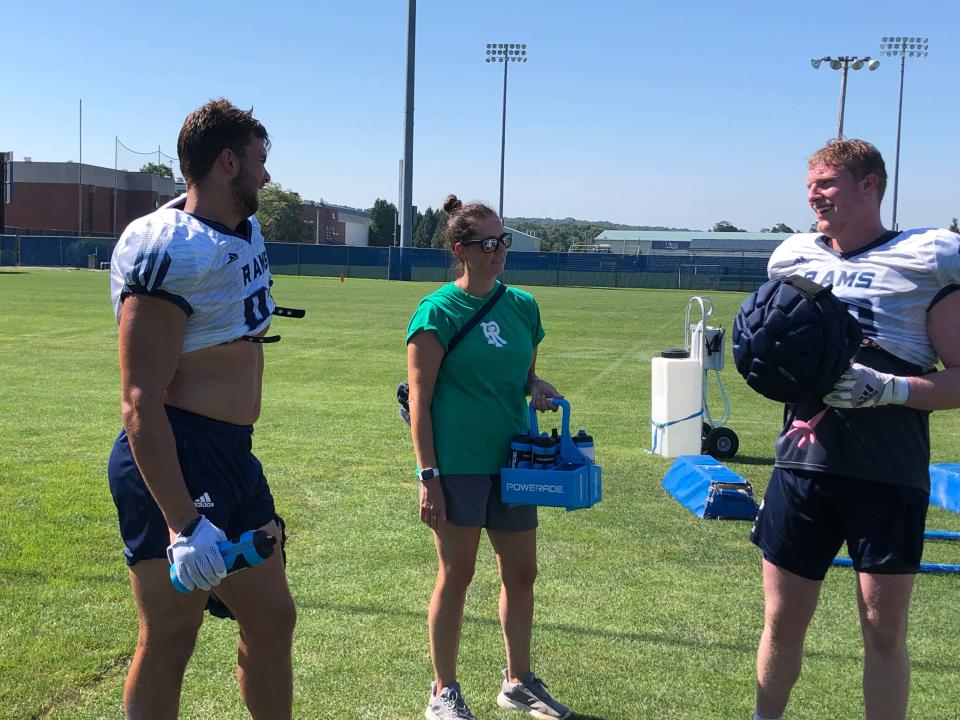 Michelle Barber works with members of the URI football team during practice last week. She has done extensive research on hydration and young athletes in her career.