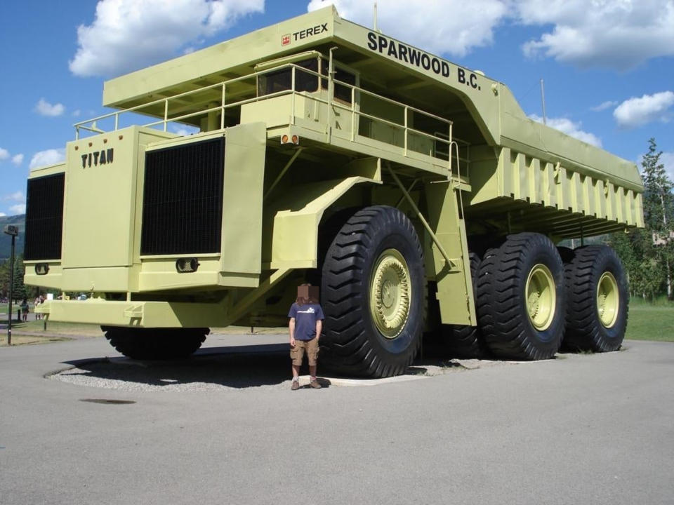 A person standing next to the truck — the person reaches about half the height of the wheel