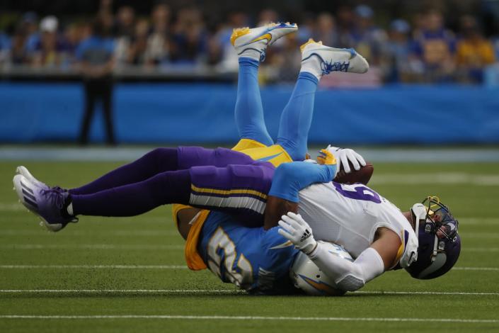 Vikings receiver Adam Thielen (19) is tackled by Chargers cornerback Chris Harris.