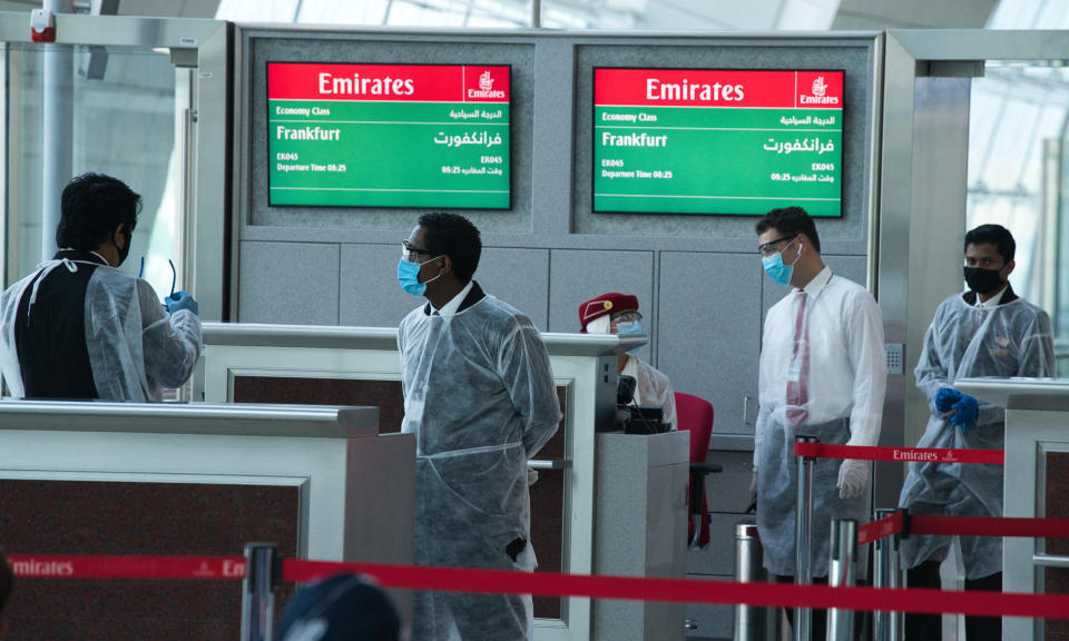 Gate staff wearing protective gear due to the coronavirus pandemic wait for boarding for an Emirates flight to Frankfurt, Germany, at Dubai International Airport's Terminal 3 in Dubai, United Arab Emirates, Wednesday, June 10, 2020. The coronavirus pandemic has hit global aviation hard, particularly at Dubai International Airport, the world's busiest for international travel, due to restrictions on global movement over the virus. (AP Photo/Jon Gambrell)