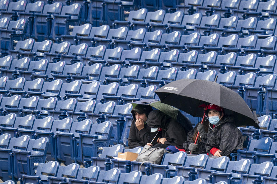 Philadelphia Phillies' fans watch the game as the rain falls during the fourth inning of a baseball game against the San Francisco Giants, Wednesday, April 21, 2021, in Philadelphia. (AP Photo/Chris Szagola)