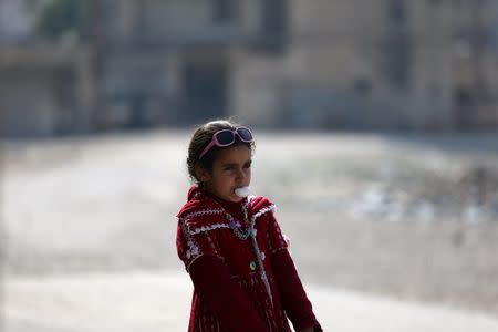 A girl blows a bubble gum on a street in Douma, Syria February 3, 2016. REUTERS/Bassam Khabieh