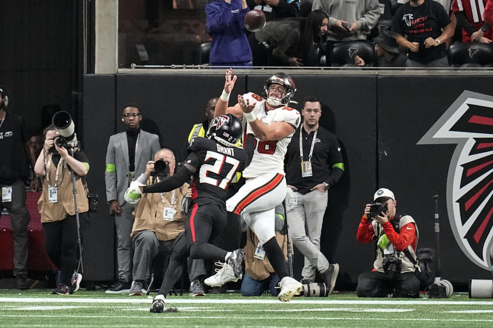 Tampa Bay Buccaneers tight end Cade Otton (88) catches a touchdown pass as Atlanta Falcons safety Richie Grant (27) defends during the second half of an NFL football game, Sunday, Dec. 10, 2023, in Atlanta. (AP Photo/Mike Stewart)