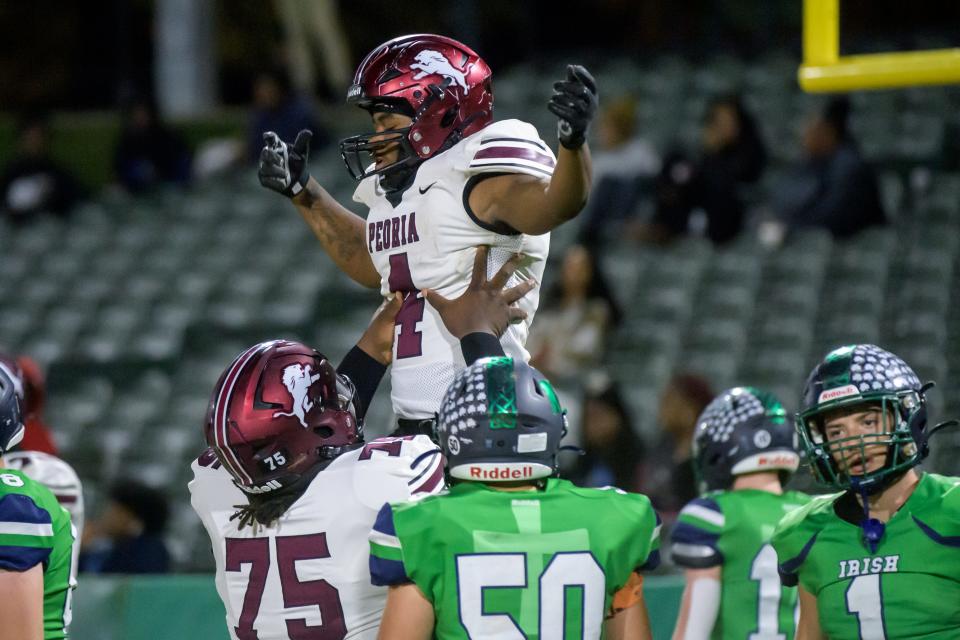 Peoria High's JaQuarius Green (75) lifts teammate Maliek Ross after a touchdown against Peoria Notre Dame in the first half of their Week 9 football game Friday, Oct. 20, 2023 at Dozer Park in Peoria.