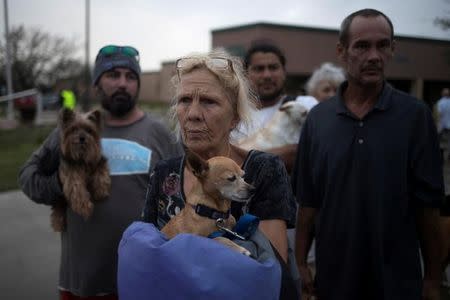 FILE PHOTO: Julie holds her dog Pee-wee as they stand in line to be evacuated to Austin after losing their home to Hurricane Harvey in Rockport, Texas, U.S. August 26, 2017. REUTERS/Adrees Latif/File Photo