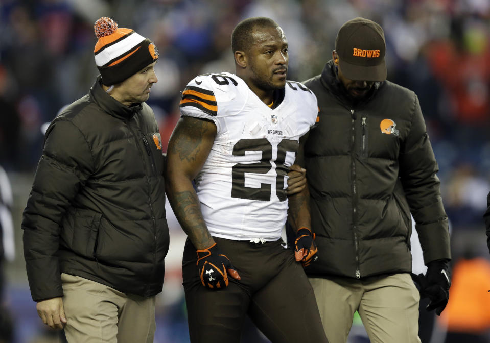 FILE - Cleveland Browns running back Willis McGahee is helped from the field after getting injured in the fourth quarter of an NFL football game against the New England Patriots on Dec. 8, 2013, in Foxborough, Mass. Ten retired NFL players, including McGahee, accused the league of lies, bad faith and flagrant violations of federal law in denying disability benefits in a potential class action lawsuit filed Thursday, Feb. 9, 2023, in Baltimore. The men say they left the game with lingering physical or cognitive injuries that make their daily lives difficult if not excruciating. (AP Photo/Steven Senne, File)