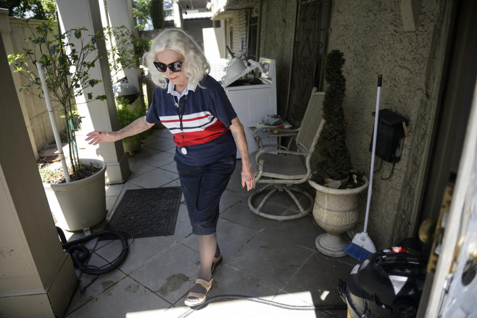 Home owner Billye Ber walks past an apartment on the ground level that was flooded after severe weather Wednesday caused street flooding in the Broadmoor neighborhood in New Orleans, Thursday, July 11, 2019. (Max Becherer/The Advocate via AP)