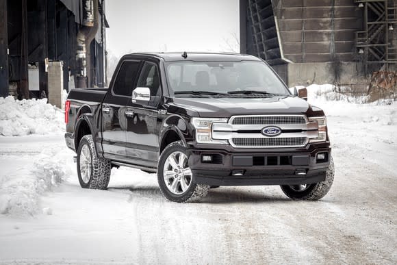 A black 2018 Ford F-150 pickup parked on a snowy road.