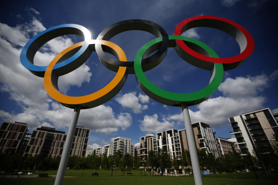 A set of Olympic rings are seen standing in front of apartments for athletes during a media opportunity at the Olympic and Paralympic athlete's village in London, Thursday, July 12, 2012. The London Olympics begin on July 27. (AP Photo/Matt Dunham)