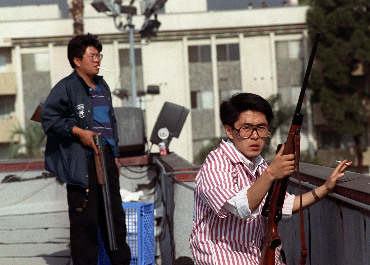 Two Korean men stand on the roof of a grocery store 