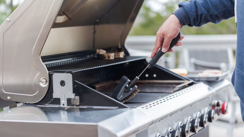 man cleaning grill