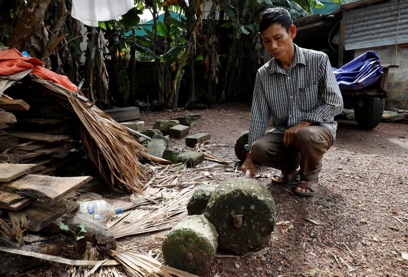 Nguyen Dinh Gia shows a barbell which was used by his son Nguyen Dinh Luong, a victim who was found dead in the back of British truck, at home in Ha Tinh province