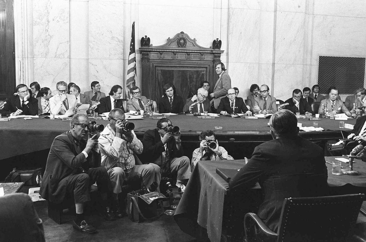 FILE - The Senate Watergate Committee hearings continue on Capitol Hill in Washington, Aug. 3, 1973. From left are: Sen. Lowell P. Weicker, Jr; Sen. Edward J. Gurney, Fred Thompson, Sen. Howard H. Baker, Jr; Rufus Edmisten, Sen. Sam Ervin; Sam Dash, Sen. Joseph M. Montoya, Sen. Daniel K. Inouye was absent. Testifying is Lt. Gen. Vernon Walters. Nixon resigned from office in August 1974 rather than face impeachment for his administration’s coverup of its involvement in a break-in at the Democratic National Committee headquarters in Washington. (AP Photo/File)