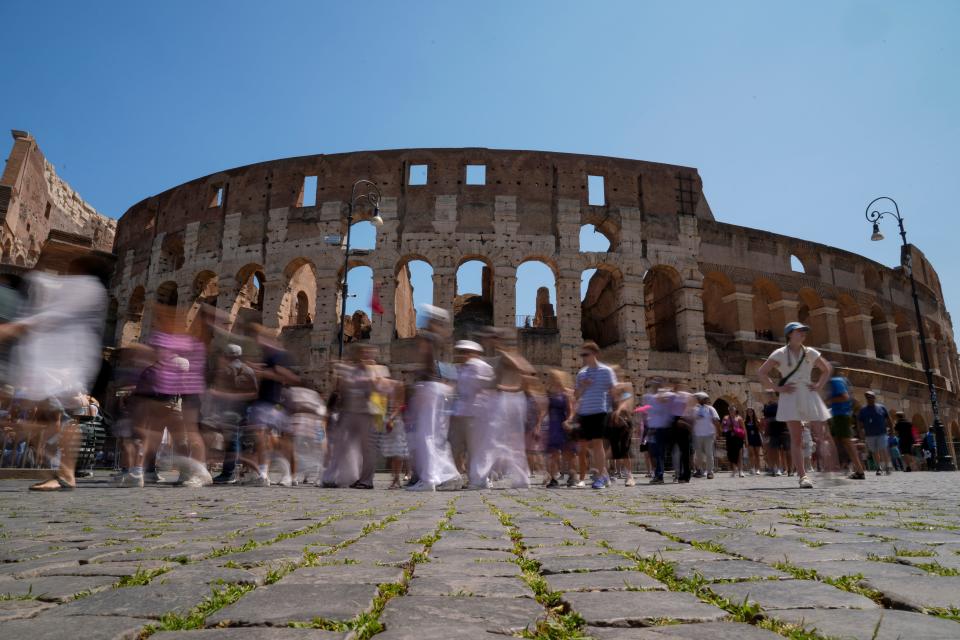 Visitors walk past the Colosseum in Rome last week. Italy's culture and tourism ministers Gennaro Sangiuliano vowed to find and punish a tourist who was filmed carving his name and his girlfriend's name in the wall of the Colosseum, a crime that in the past has resulted in hefty fines. Video of the incident went viral on social media, at a time when Romans have already been complaining about hordes of tourists returning to peak season travel this year.