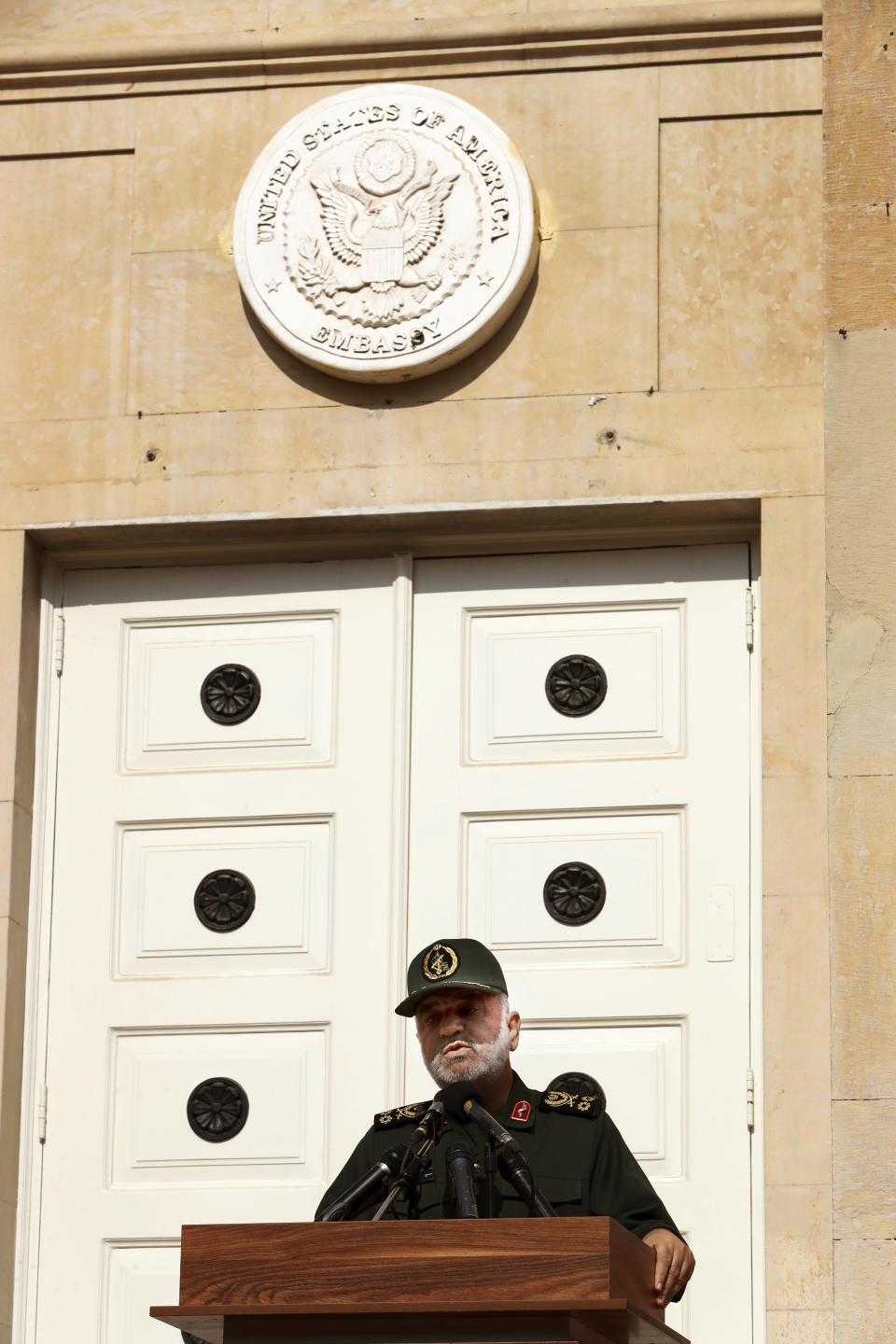 Chief of Iran's Revolutionary Guard Gen. Hossein Salami speaks in a ceremony to unveil new anti-U.S. murals painted on the walls of former U.S. embassy as emblem of the embassy is seen above, in Tehran, Iran, Saturday, Nov. 2, 2019. Anti-U.S. works of graphics is the main theme of the wall murals painted by a team of artists ahead of the 40th anniversary of the takeover of the U.S. diplomatic post by revolutionary students. (AP Photo/Vahid Salemi)