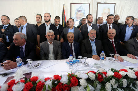 Palestinian Prime Minister Rami Hamdallah (R) sits next to Hamas Chief Ismail Haniyeh in Gaza City October 2, 2017. REUTERS/Ibraheem Abu Mustafa
