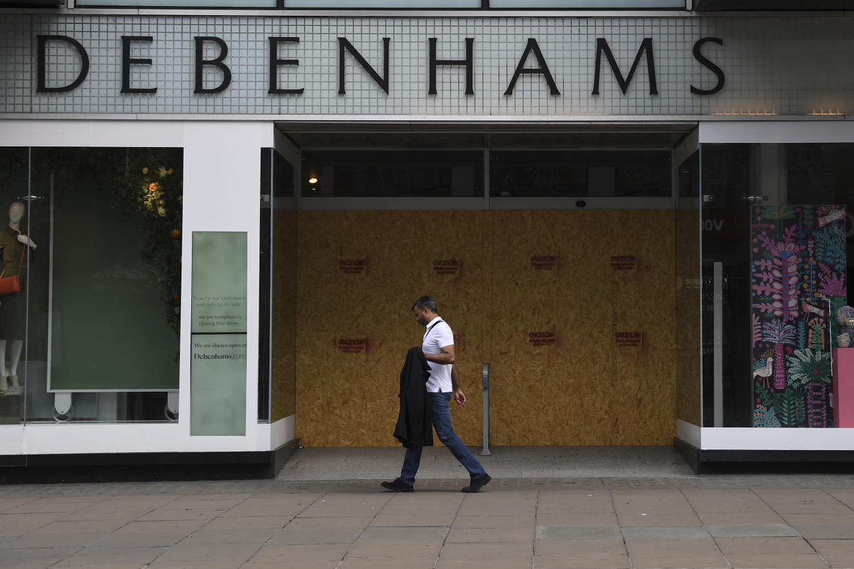 A man walks past a Debenhams store in the main shopping street Oxford Street, ahead of the reopening of the non-essential businesses on Monday, June 15, as some of the coronavirus lockdown measures are eased, in London, Friday, June 12, 2020. The British economy shrank by a colossal 20.4% in April, the first full month that the country was in its coronavirus lockdown, official figures showed Friday. (AP Photo/Alberto Pezzali)