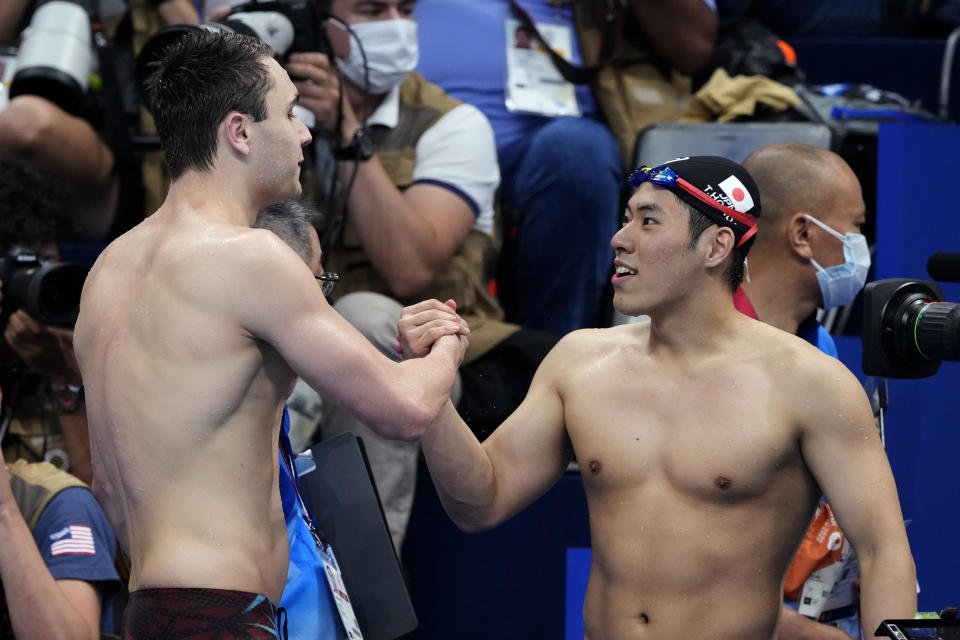 Kristof Milak, left, of Hungary, is congratulated by second placed Tomoru Honda, of Japan, after winning the men's 200-meter butterfly final after at the 2020 Summer Olympics, Wednesday, July 28, 2021, in Tokyo, Japan. (AP Photo/Martin Meissner)