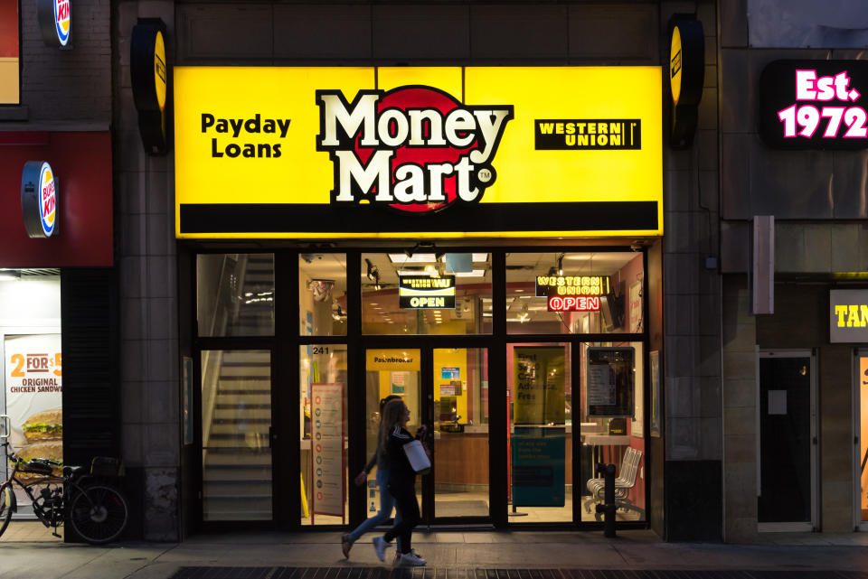 DOWNTOWN, TORONTO, ONTARIO, CANADA - 2015/08/23: People walking in front of a Money Mart store in Toronto. National Money Mart Company, commonly known as Money Mart, is a Canadian financial services company that provides payday loans, cheque cashing, tax preparation and money transfer services to the underbanked. (Photo by Roberto Machado Noa/LightRocket via Getty Images)