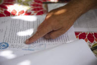 Adel Budeiri points to a document in a court case for several Palestinian families, including his own, who are at risk of forcible eviction from their homes in the Sheikh Jarrah neighborhood of east Jerusalem, Sunday, May 9, 2021. Dozens of Palestinian families in east Jerusalem are at risk of losing their homes to Jewish settler groups following a decades-long legal battle. (AP Photo/Maya Alleruzzo)