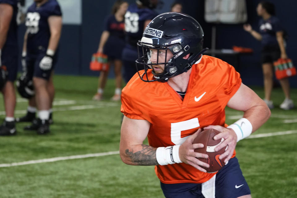 FILE - Virginia quarterback Brennan Armstrong participates in drills during practice for the NCAA college football team Wednesday Aug. 3, 2022, in Charlottesville, Va. Veteran quarterbacks are plentiful in the Atlantic Coast Conference this season. In all, 12 of the 14 league teams have at least one quarterback with nine or more career starts. (AP Photo/Steve Helber, File)