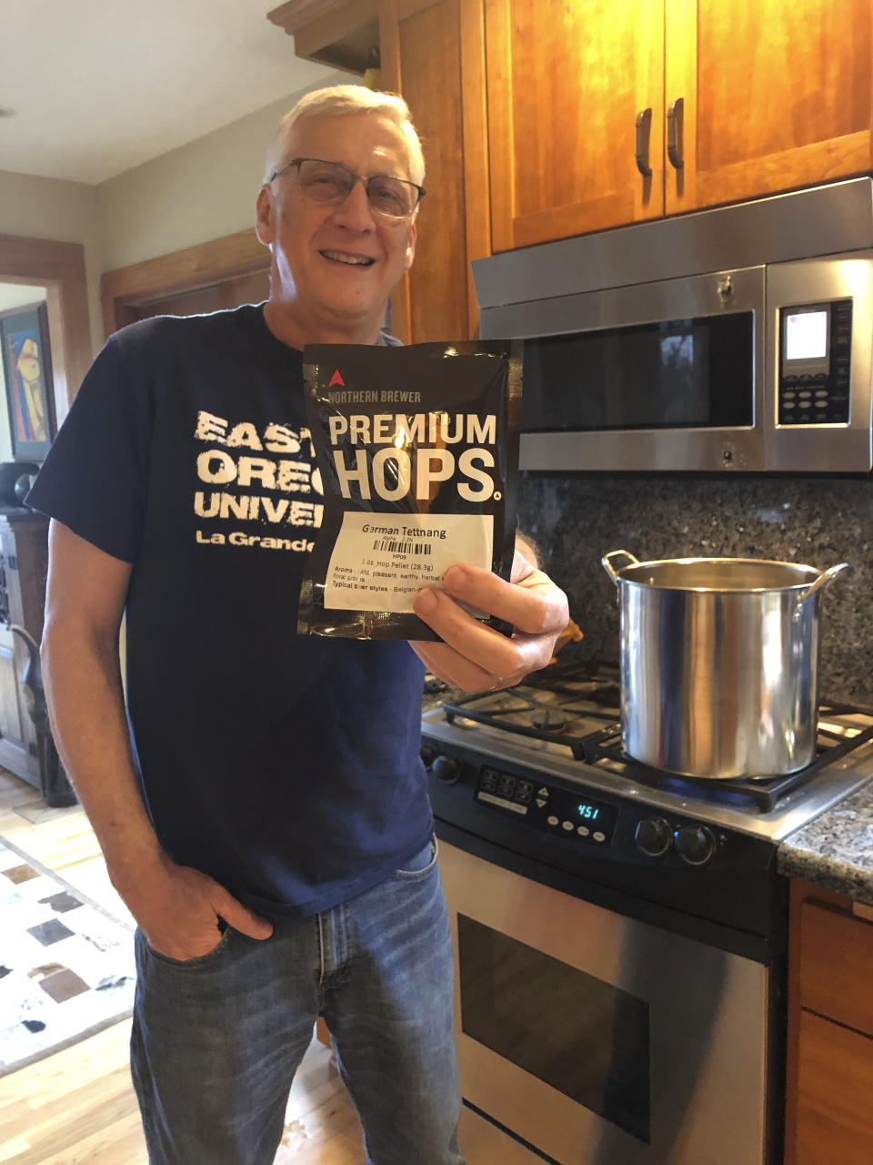 This March 14, 2020 photo shows Andrew Selsky holding a bag of hops for home-brewed German-style hefeweizen in Salem, Ore. Homebrewing provides an escape from dwelling on the COVID-19 pandemic. (AP Photo/Zoe Selsky)