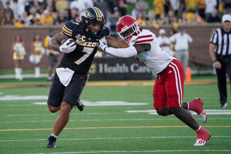 Missouri Tigers running back Cody Schrader (7) runs the ball as South Dakota Coyotes defensive back Dennis Shorter (2) attempts the tackle during the first half at Faurot Field at Memorial Stadium.