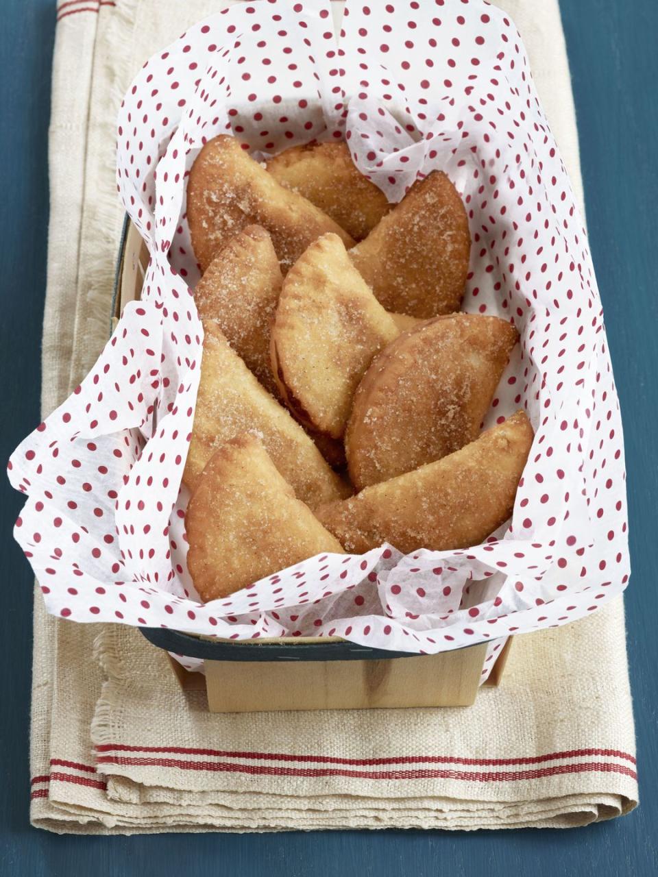 fried peach pies arranged in a parchment lined box