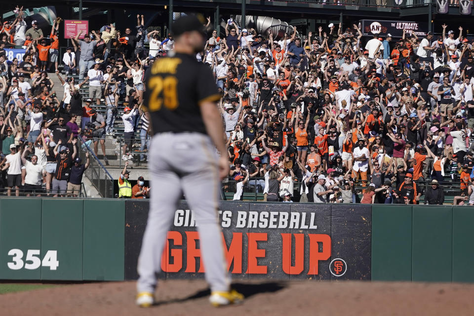 Fans cheer as Pittsburgh Pirates pitcher Wil Crowe, foreground, reacts after San Francisco Giants' Thairo Estrada hit a two-run home run during the ninth inning of a baseball game in San Francisco, Sunday, Aug. 14, 2022. (AP Photo/Jeff Chiu)