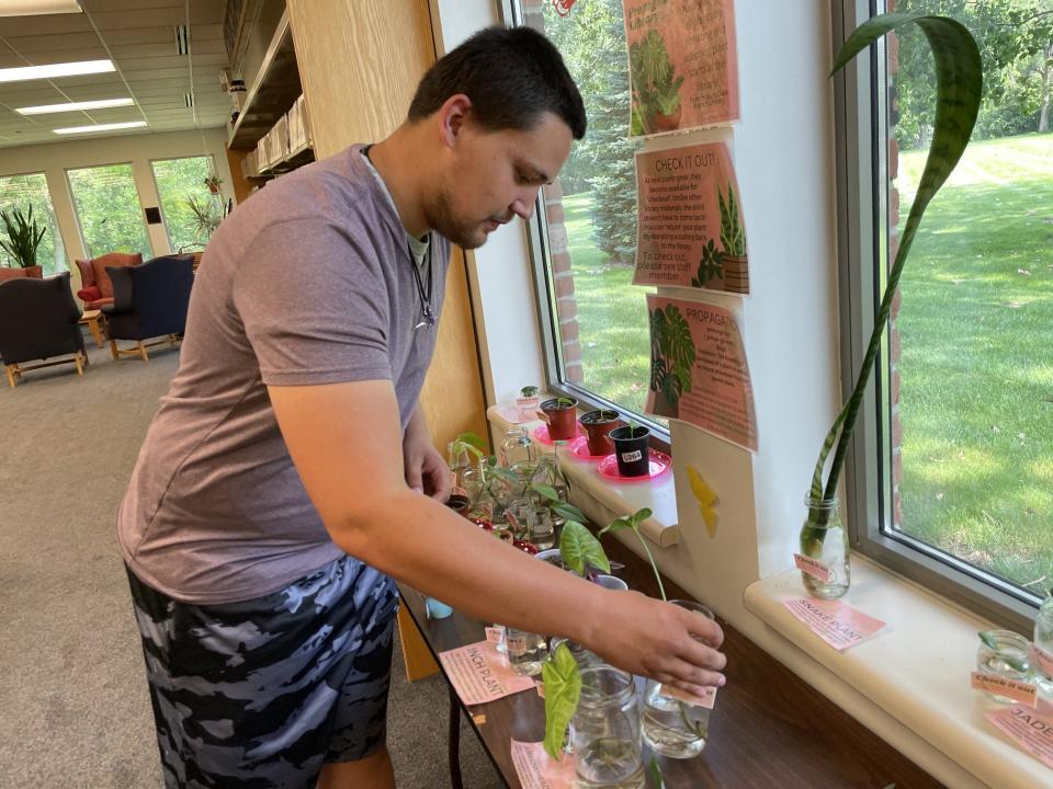 Frenchtown-Dixie Branch patron Preston LeFevre, 23, of Monroe, looks at the houseplant collection at the branch.