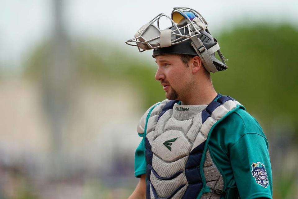 Seattle Mariners catcher Cal Raleigh looks on during the second inning of a spring training baseball game against the Texas Rangers, Sunday, March 19, 2023, in Surprise, Arizona.