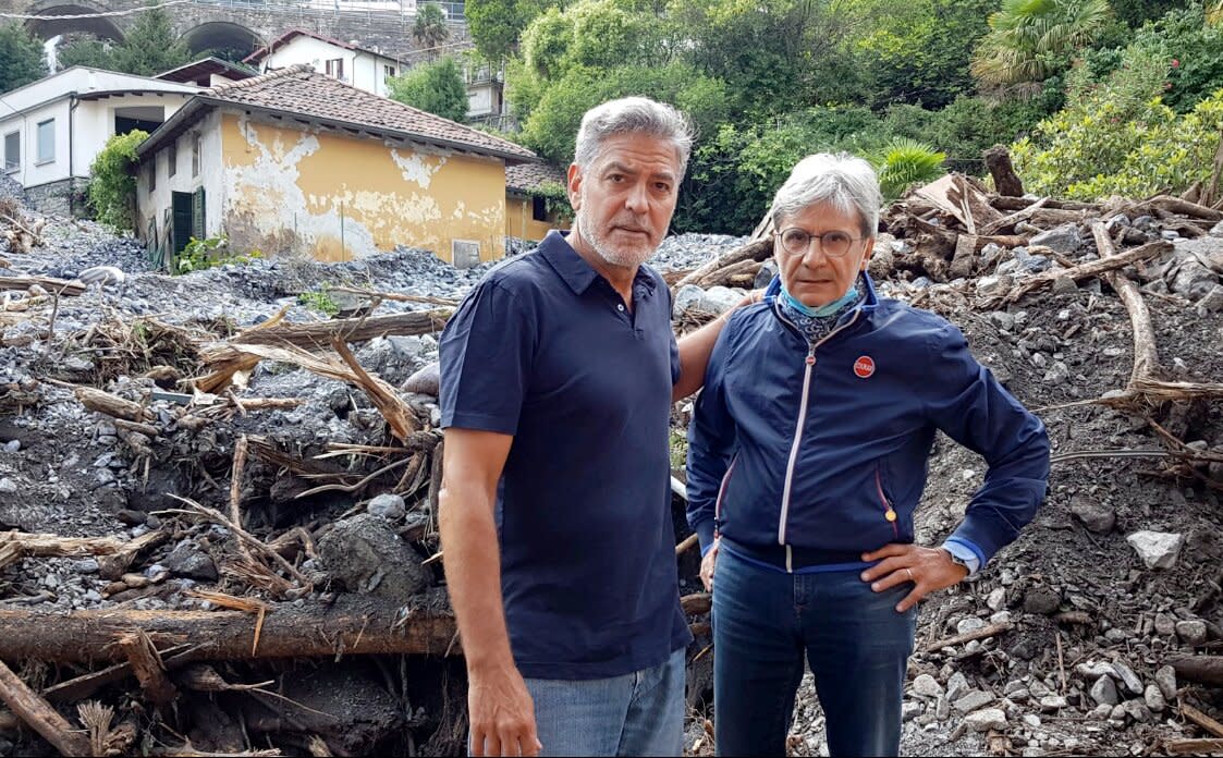 Mayor of Laglio Roberto Pozzi with George Clooney in the midst of rubble caused by bad weather in Laglio on July 28, 2021.