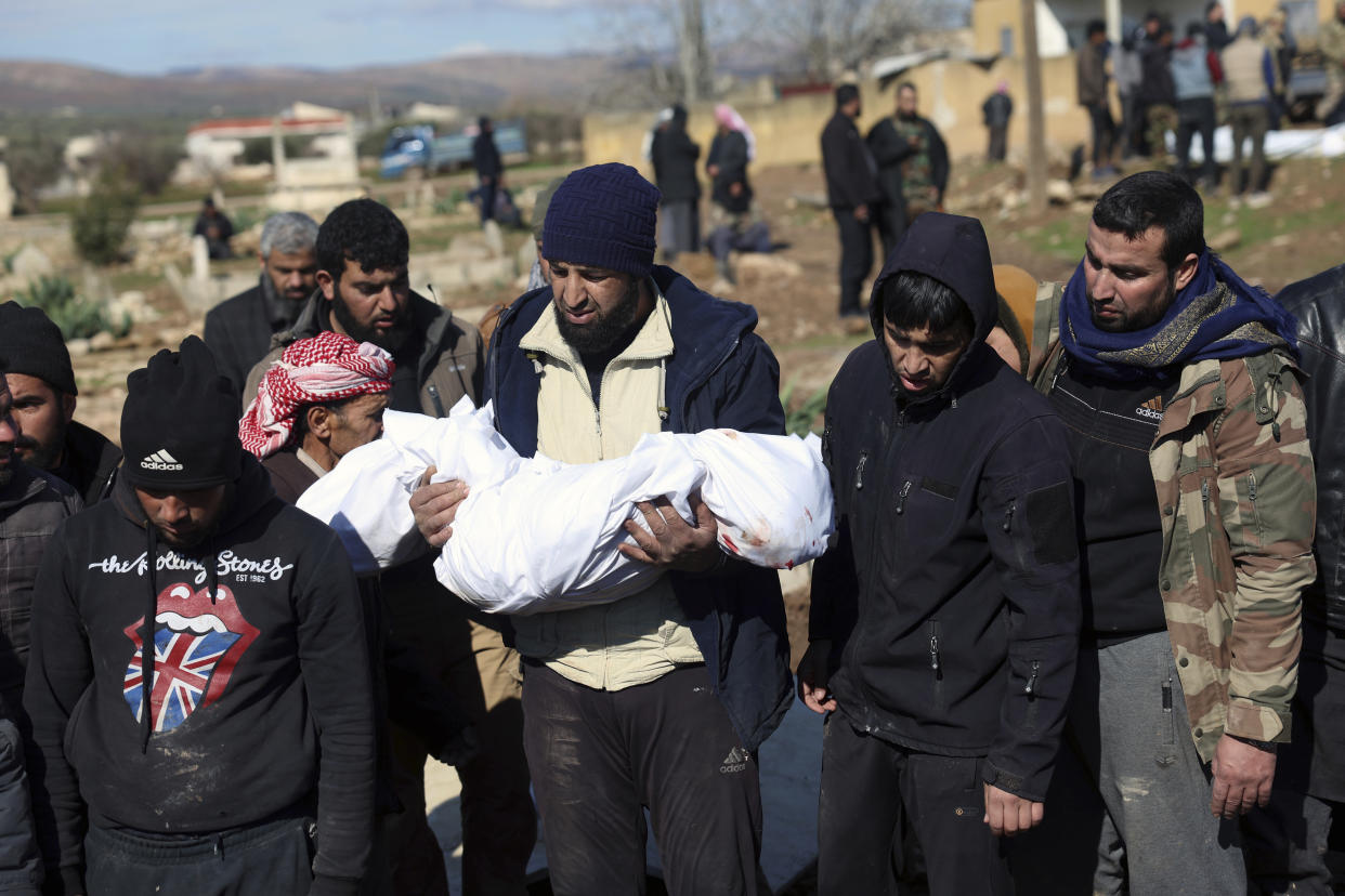 Mourners bury family members who died in a devastating earthquake that rocked Syria and Turkey at a cemetery in the town of Jinderis, Aleppo province, Syria, Tuesday, Feb. 7, 2023. A newborn girl was found buried under debris with her umbilical cord still connected to her mother, Afraa Abu Hadiya, who was found dead, according to relatives and a doctor. The baby was the only member of her family to survive from the building collapse Monday in Jinderis, next to the Turkish border, Ramadan Sleiman, a relative, told The Associated Press. (AP Photo/Ghaith Alsayed)