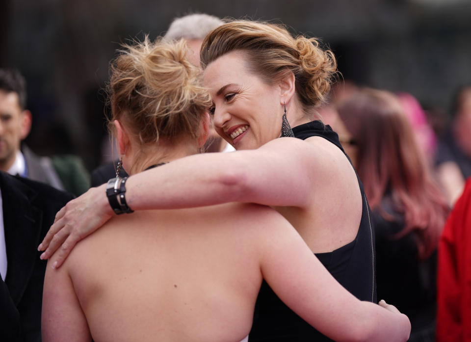 Kate and Mia embrace from behind